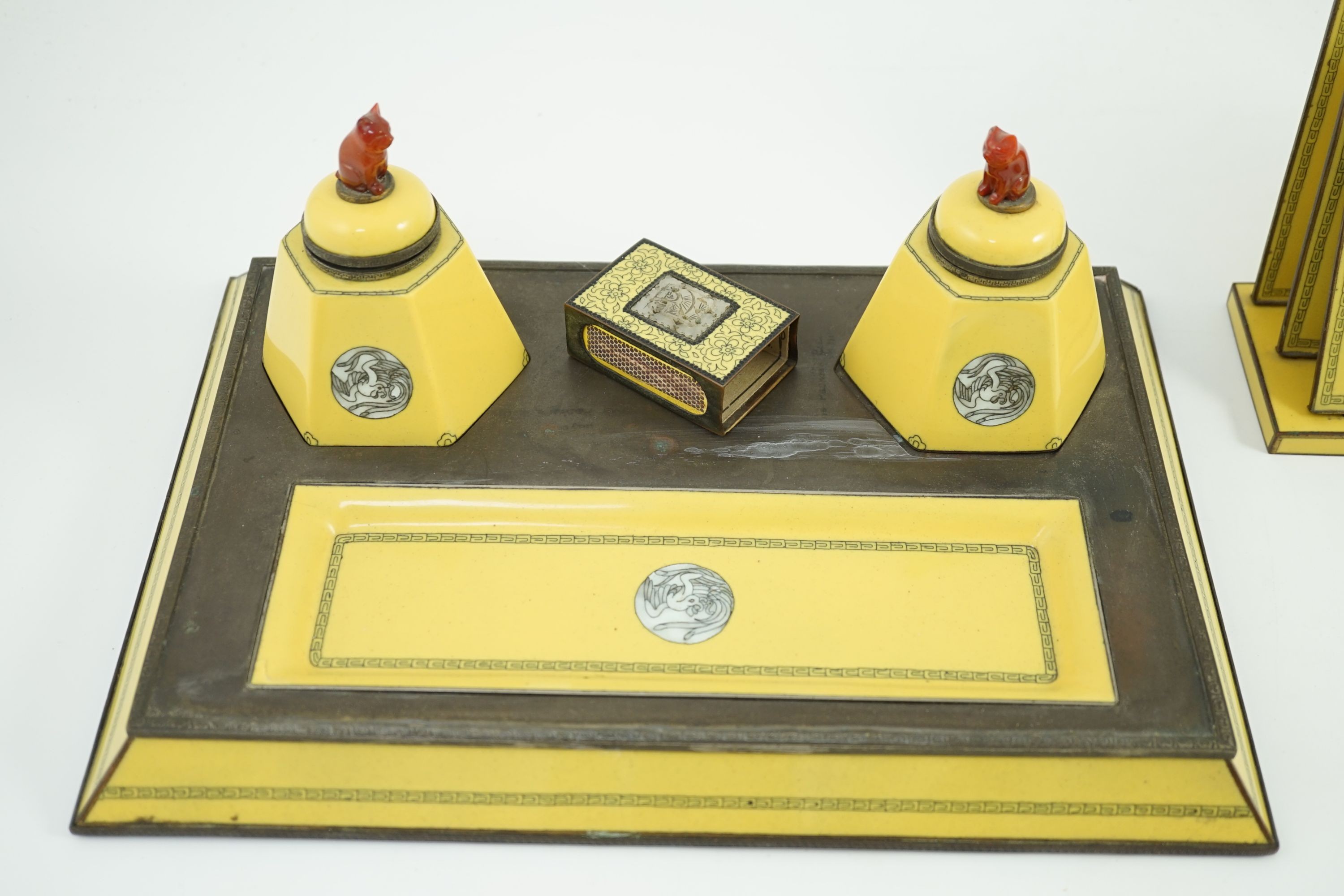 A Japanese cloisonné enamel desk set, 1920s, mounted with two Chinese Qing dynasty pale celadon jade plaques, retailed by Yamanaka & Co., Inkstand 31cm wide